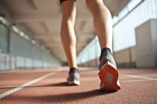 Free Fit runner standing on racetrack in athletics arena Stock Photo
