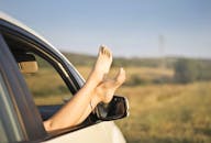 在无忧无虑的夏季公路旅行中，赤脚伸出车窗，拥抱自由与放松