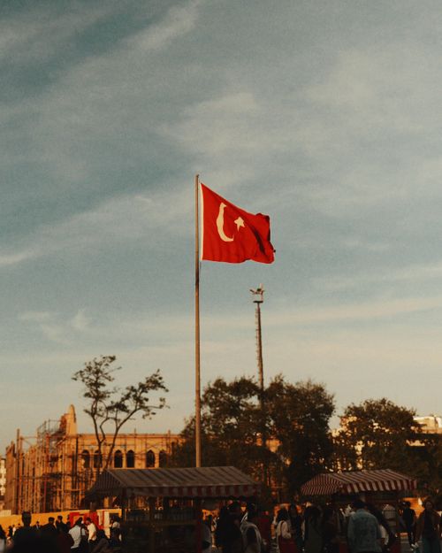 Free Turkish flag waving in a busy İstanbul square under a clear sky. Stock Photo