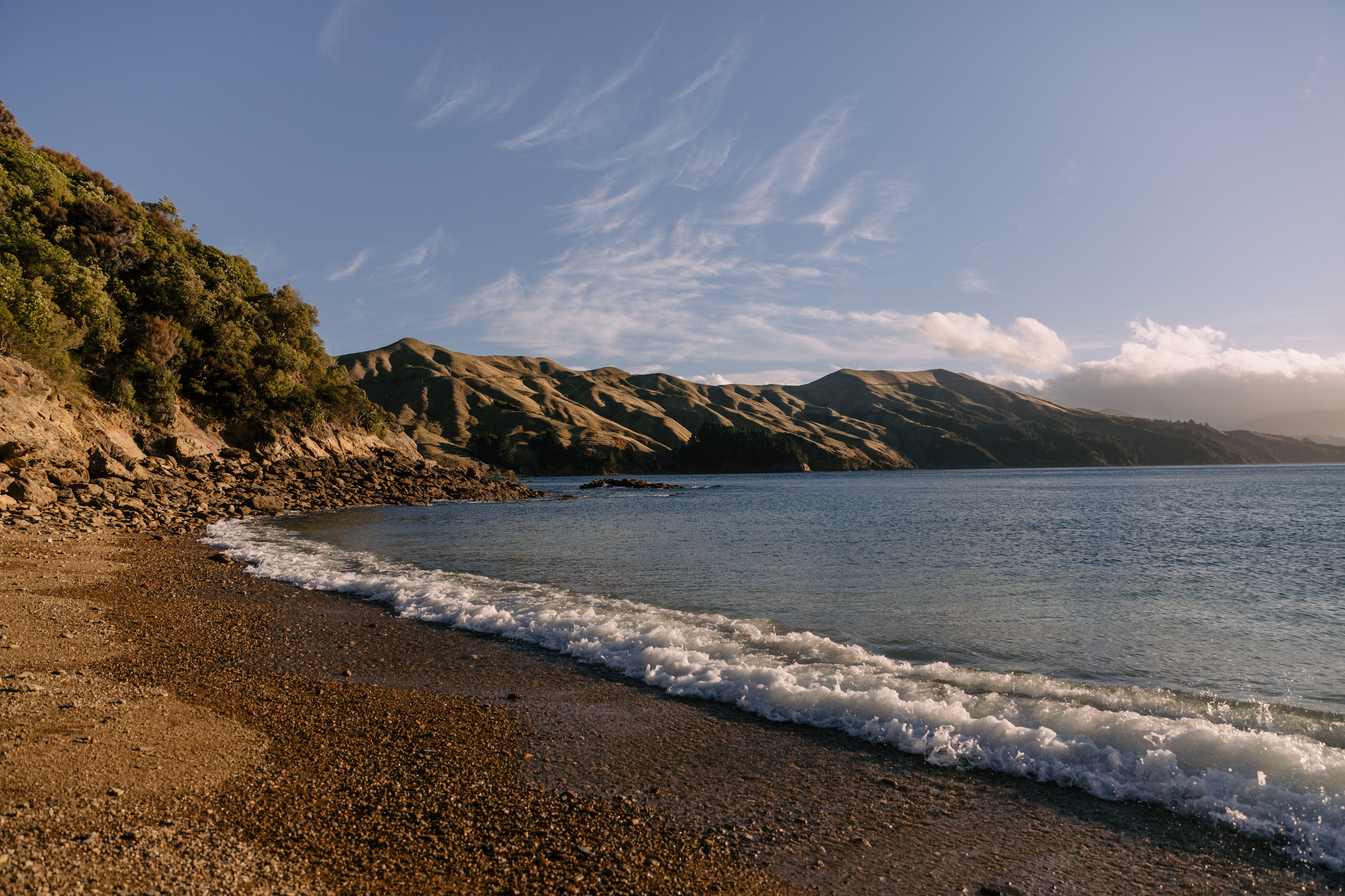 Explore the stunning beach and coastal landscape of Marlborough Sounds, New Zealand at sunset.