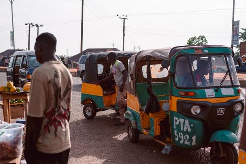 Free Colorful market scene featuring auto rickshaws and vendors at a bustling street in Jos, Nigeria. Stock Photo