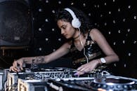 Focused ethnic female DJ playing music at nightclub