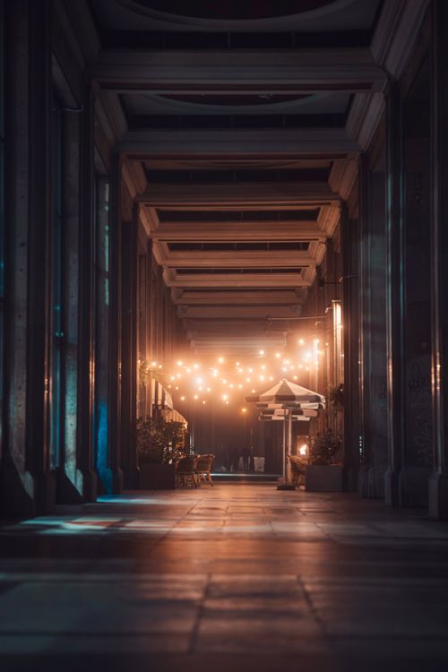 Free A captivating night view of an urban arcade adorned with string lights, creating a cozy ambiance. Stock Photo
