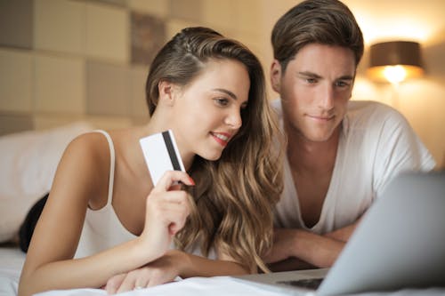 Gratis Pasangan Yang Ceria Melakukan Pembelian Online Di Rumah Foto Stok