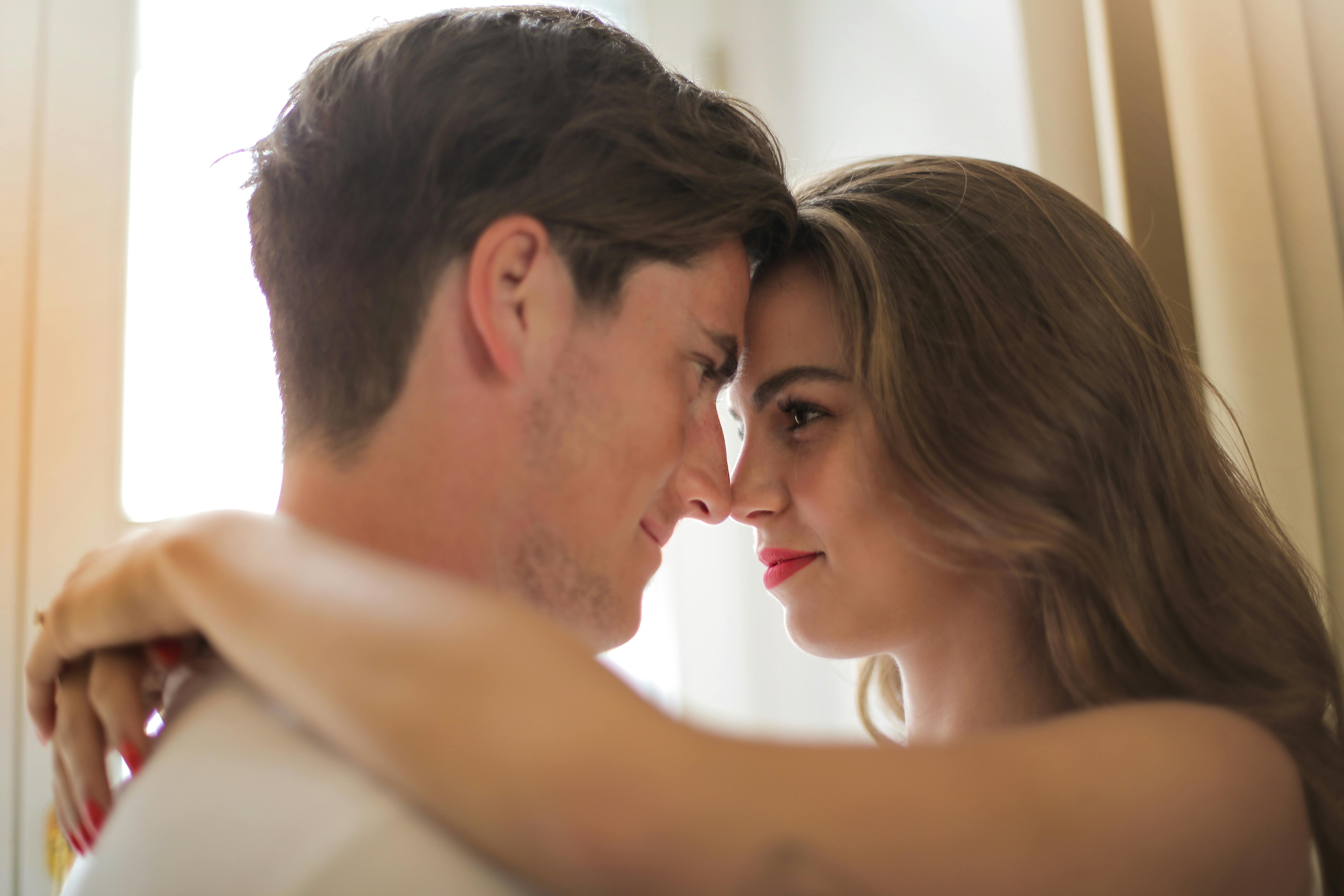 close up photo of hugging couple facing each other while smiling