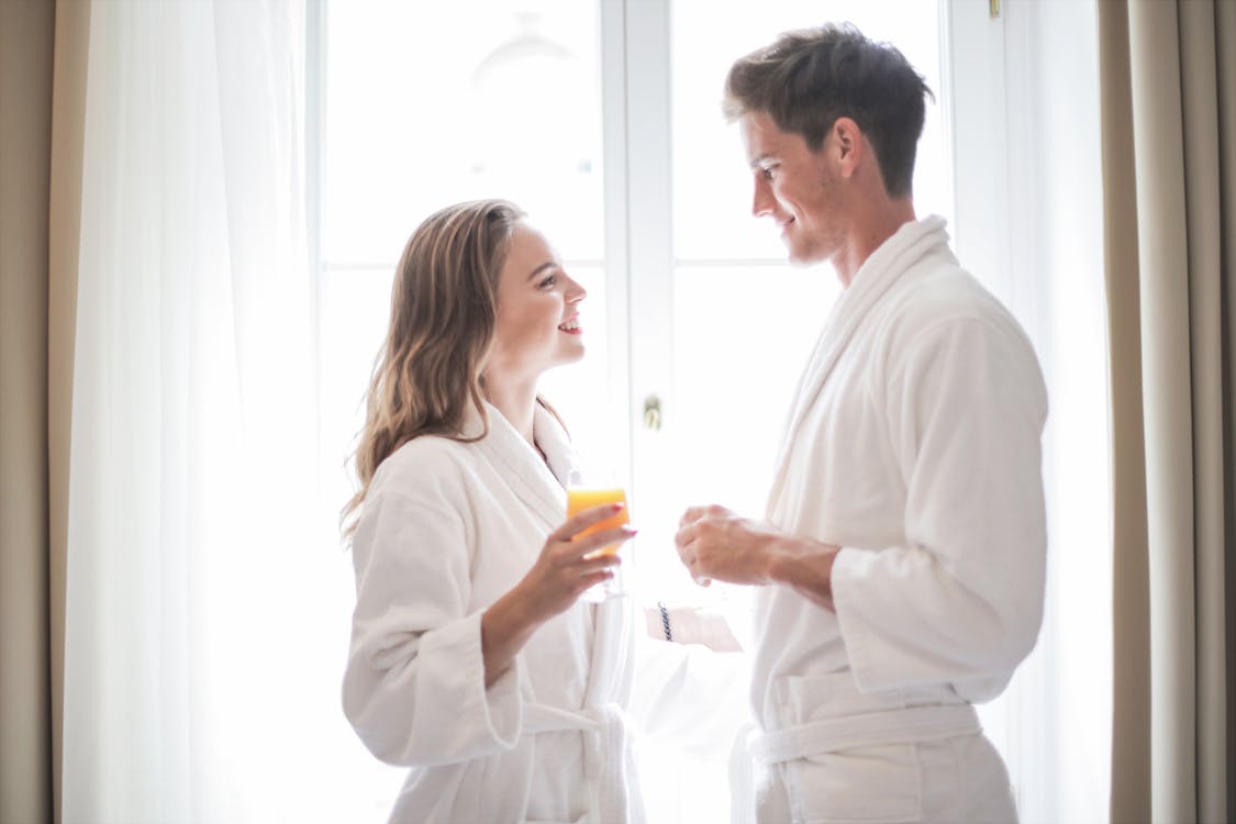 Positive couple drinking juice at home