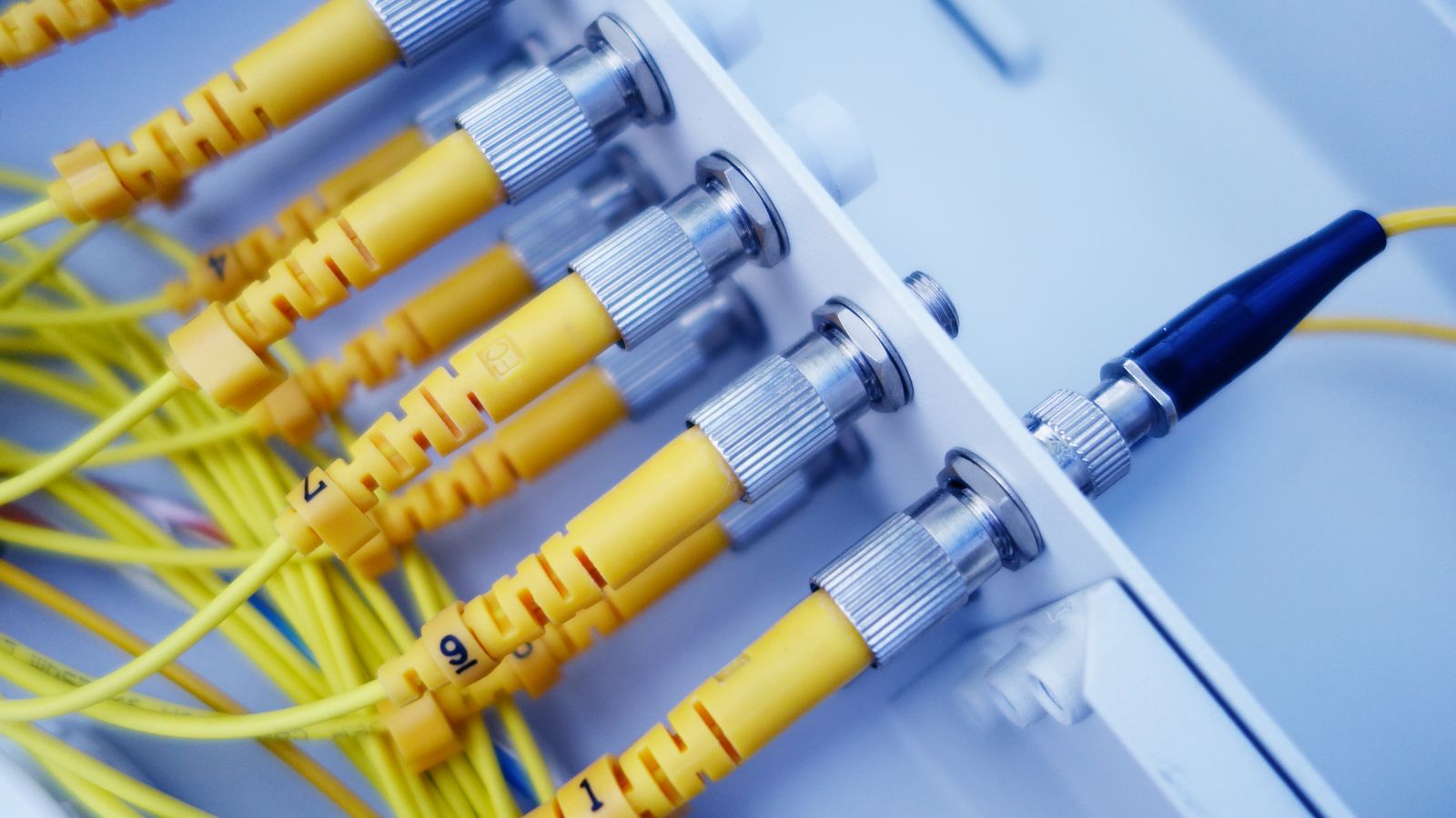 データセンター内で黄色い光ファイバーケーブルが高速なデータ転送を支える様子のイメージ