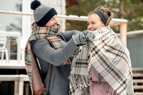 Free A couple wrapped in blankets enjoying a winter day outdoors, embodying warmth and love. Stock Photo