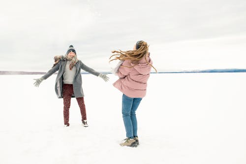 Frau In Der Rosa Jacke Und In Den Blauen Jeans, Die Neben Mann In Der Grauen Jacke Stehen