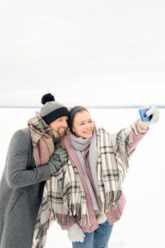 一对情侣在白雪皑皑的户外微笑着，捕捉快乐的冬日时刻