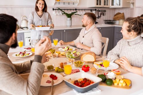 Free Group of friends enjoying a vibrant meal indoors, sharing laughter and good food. Stock Photo