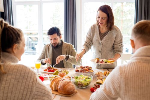 Free Warm indoor gathering with family enjoying a meal together, showcasing joy and togetherness. Stock Photo