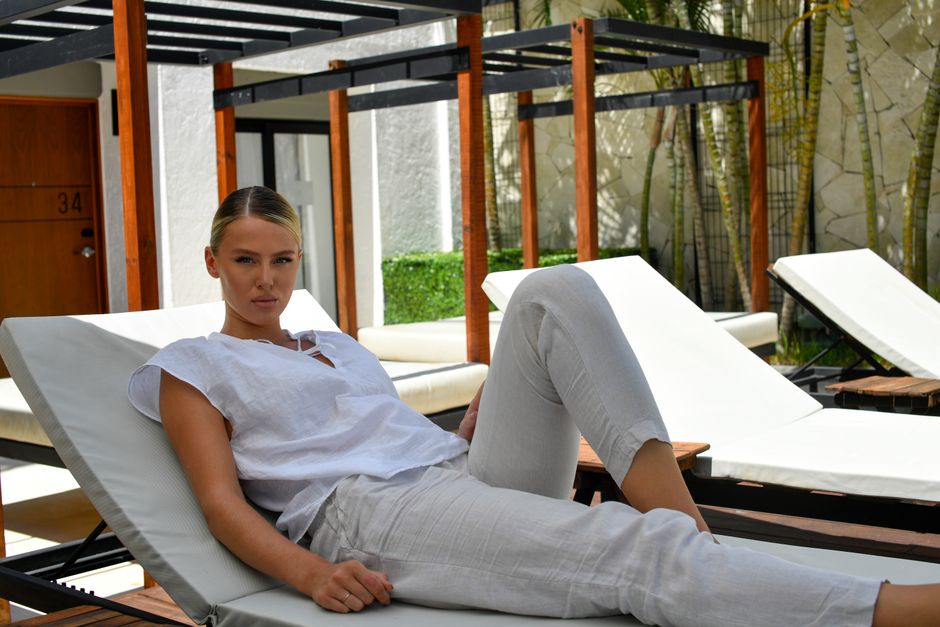 Elegant woman lounging by the pool in Cancún, exuding summer relaxation and resort vibes.