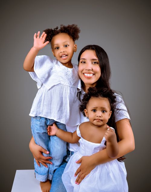 Free Joyful portrait of a mother with her two young children, showcasing love and happiness in a modern family setting. Stock Photo