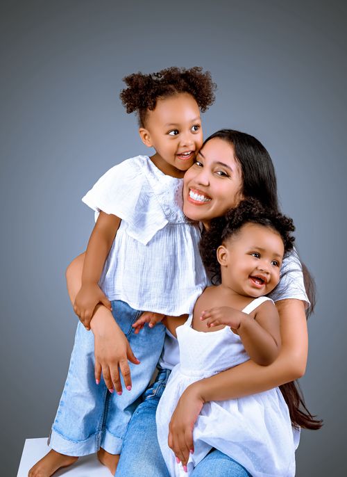 Free Joyful family portrait capturing a mother bonding with her two daughters, smiling warmly. Stock Photo