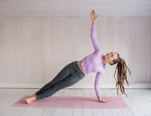 Free Woman In Pink Long Sleeve Shirt And Gray Leggings Doing Yoga Stock Photo