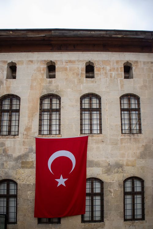 Free Facade of a historic building displaying a Turkish flag in Gaziantep, Türkiye. Capturing cultural heritage. Stock Photo