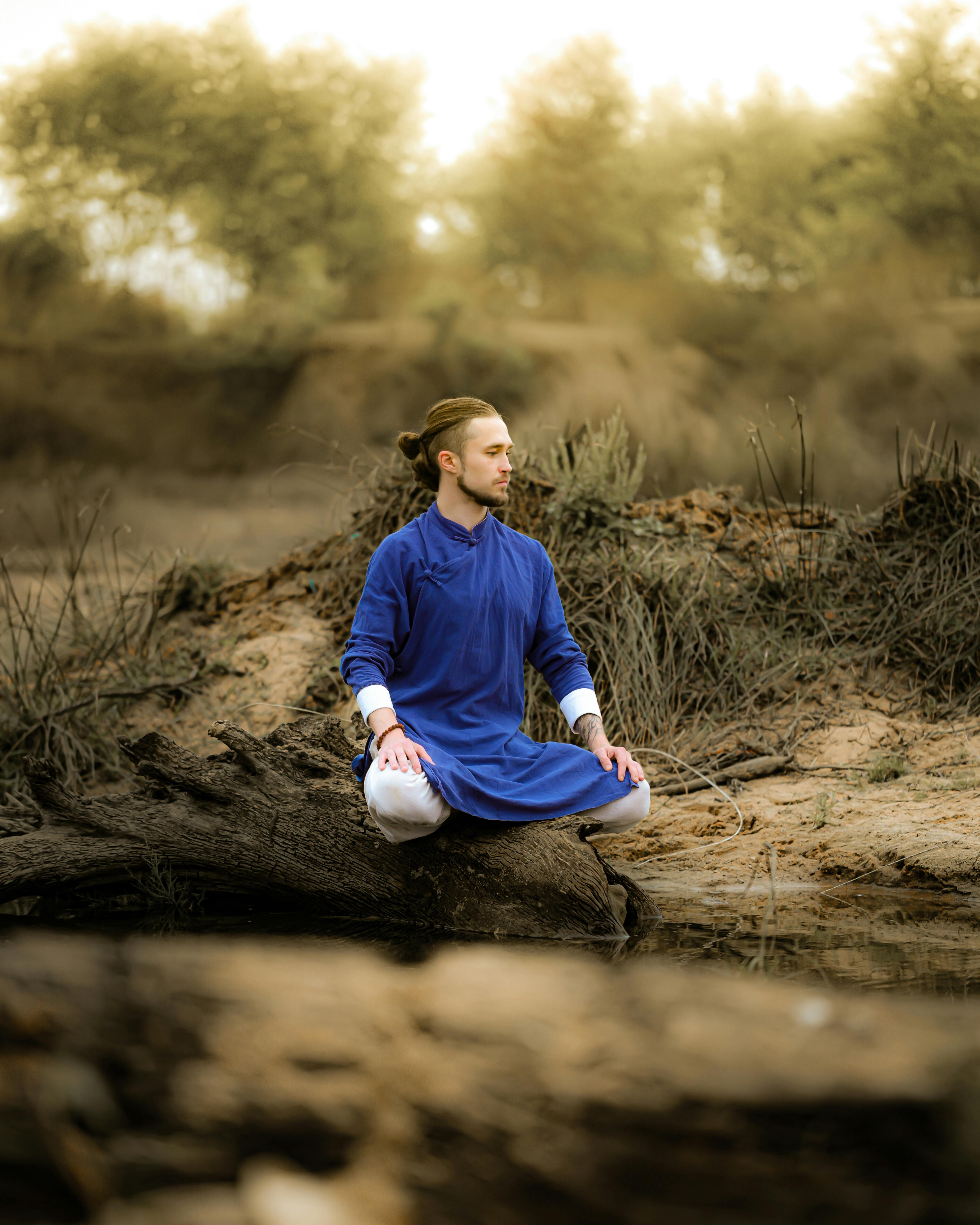 Serene image of a man meditating outdoors in a natural setting, promoting peace and mindfulness.