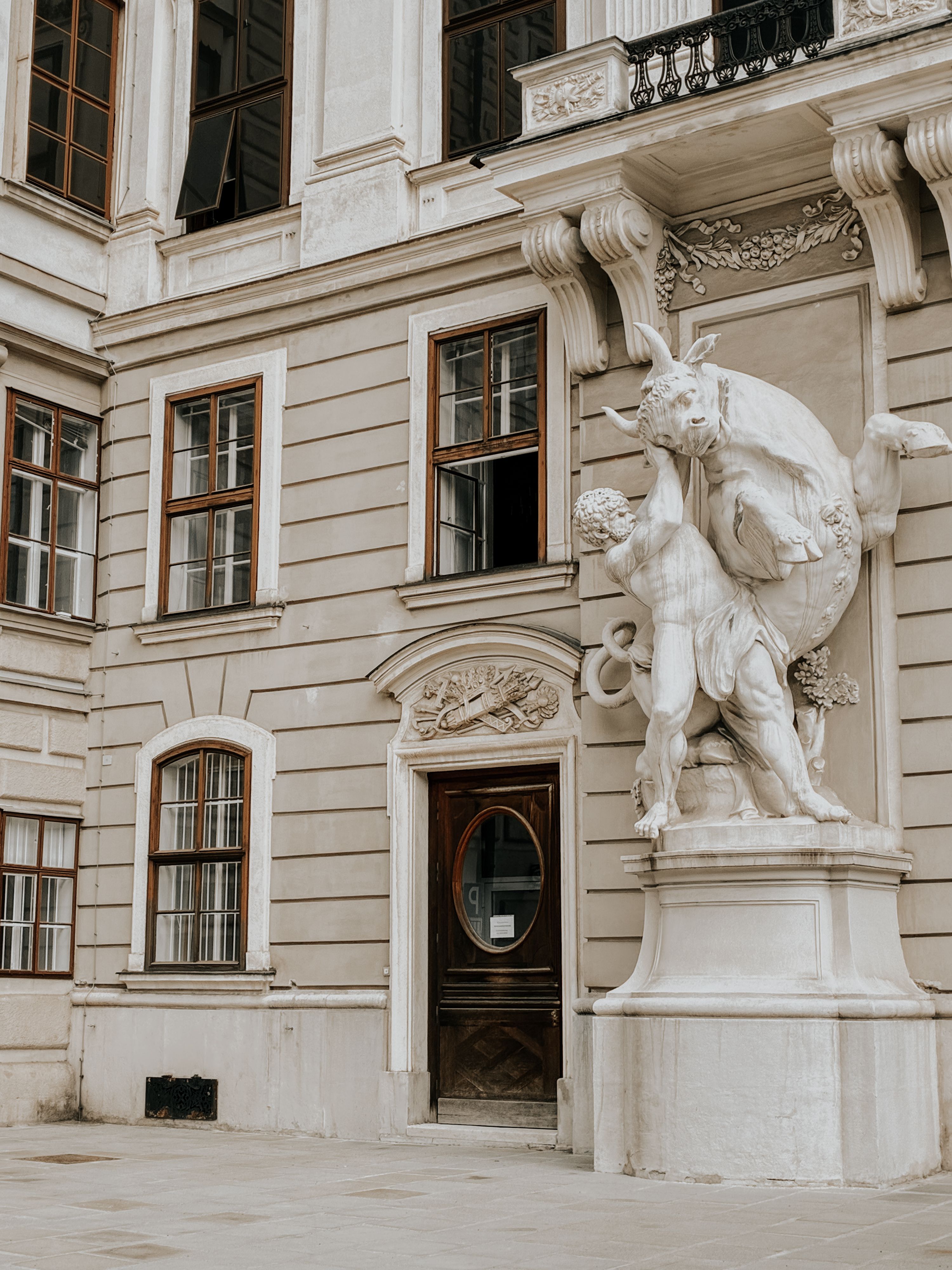 Detailed view of a Baroque sculpture outside a historic building in Vienna, Austria, showcasing classic architectural elements.