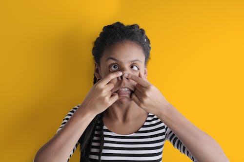 Young funny African American woman grimacing in studio