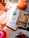 From above bright cards with colorful paintings and wise inspiring aphorisms heaped on tables among cozy candle holders and souvenirs in sunlight