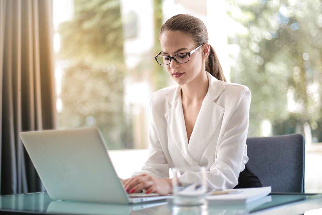 Empresaria Concentrada Escribiendo En La Computadora Portátil En El Lugar De Trabajo