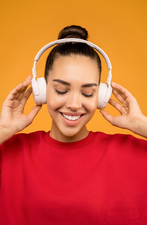 Happy Woman Listening Music on White Headphone