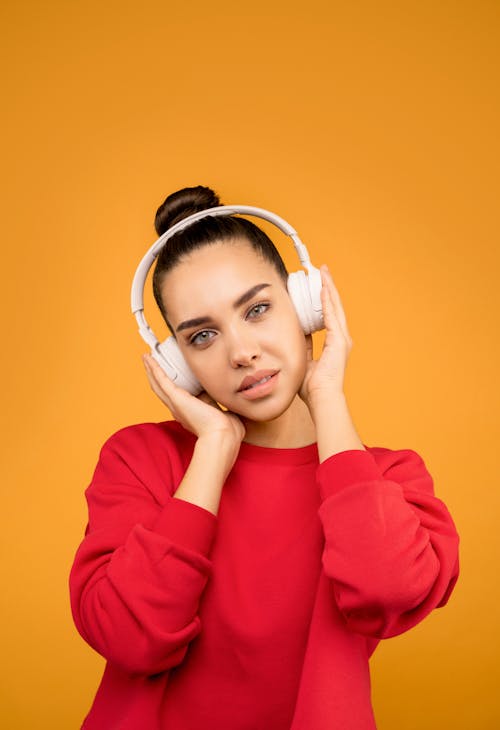 Mulher Jovem Usando Mangas Compridas Vermelhas E Fones De Ouvido Brancos