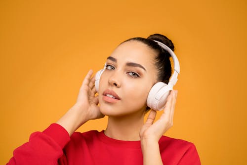 Woman Red long Sleeves Holding White Headphones