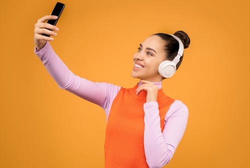 Woman in Knitted Long Sleeve Shirt Holding Black Mobile Phone