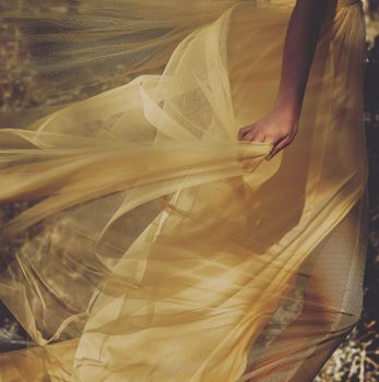 A softly flowing yellow dress captured in motion, creating a graceful and dynamic image.
