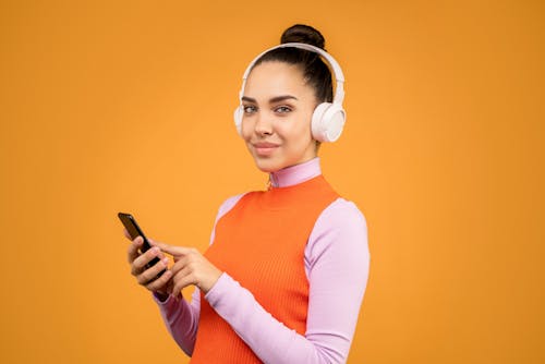 Woman in Orange Pink Long Sleeve Shirt Holding Black Smartphone