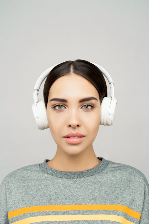 Woman in Gray Crew Neck Shirt Wearing White Headphones