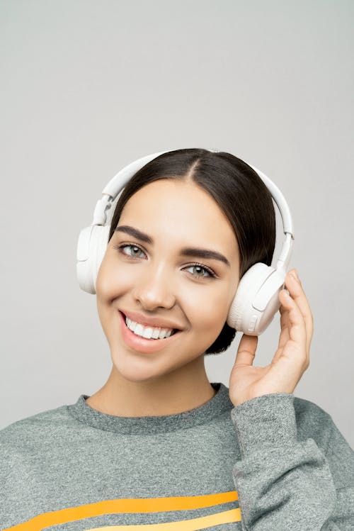 Woman in Gray Crew Neck Shirt Wearing White Headphones