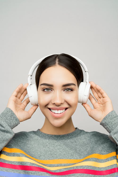Woman Holding a White Headphones