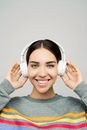 一位年轻女子在录音室里戴着耳机听音乐，微笑着的肖像