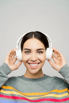 一位年轻女子在录音室里戴着耳机听音乐，微笑着的肖像