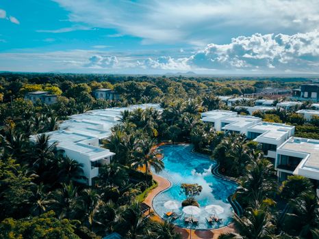 Aerial view of a luxury resort with a stunning tropical pool surrounded by lush greenery.