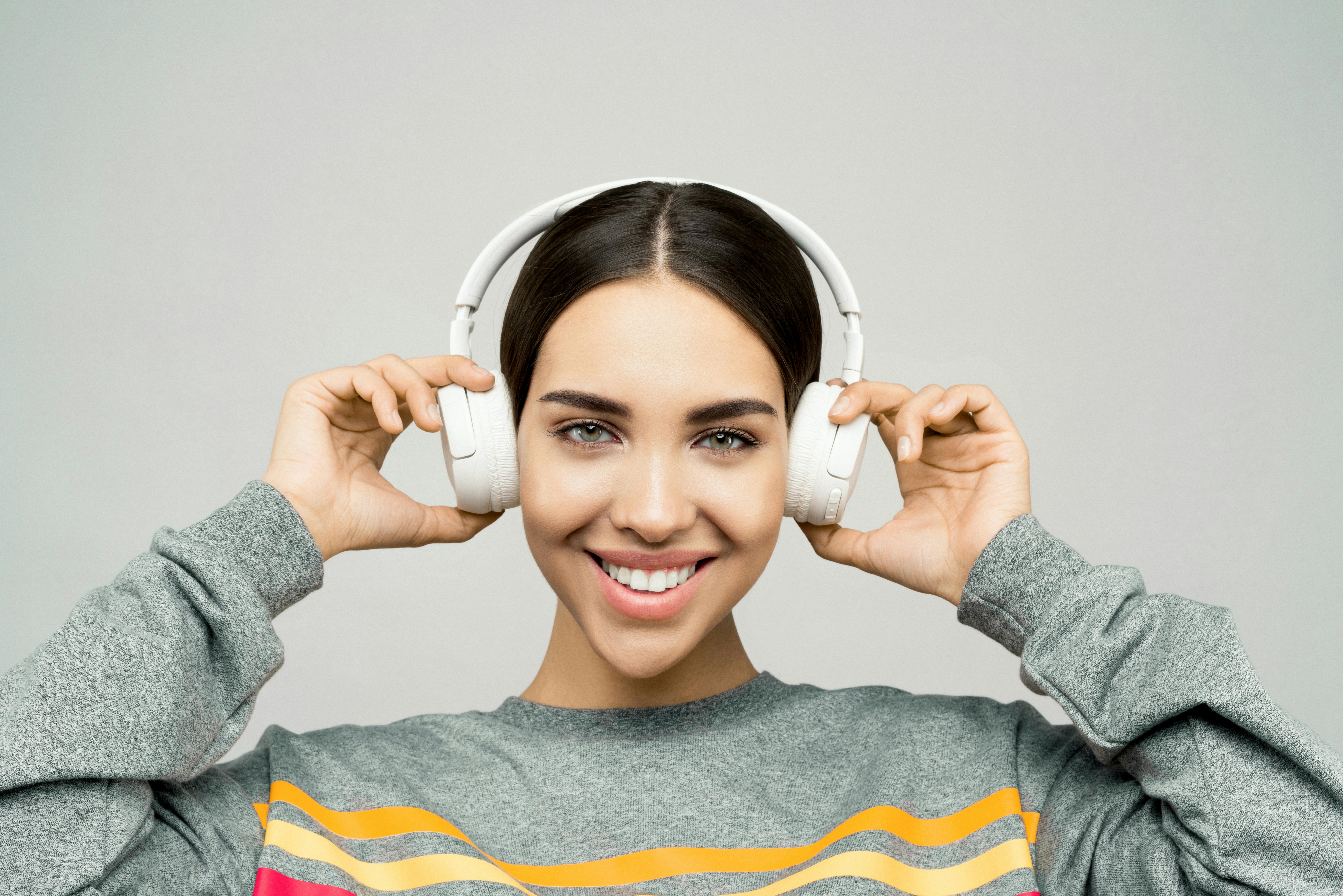 photo of woman wearing white headphones