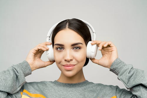 Woman in Gray Sweatshirt Wearing White Headphone Smiling