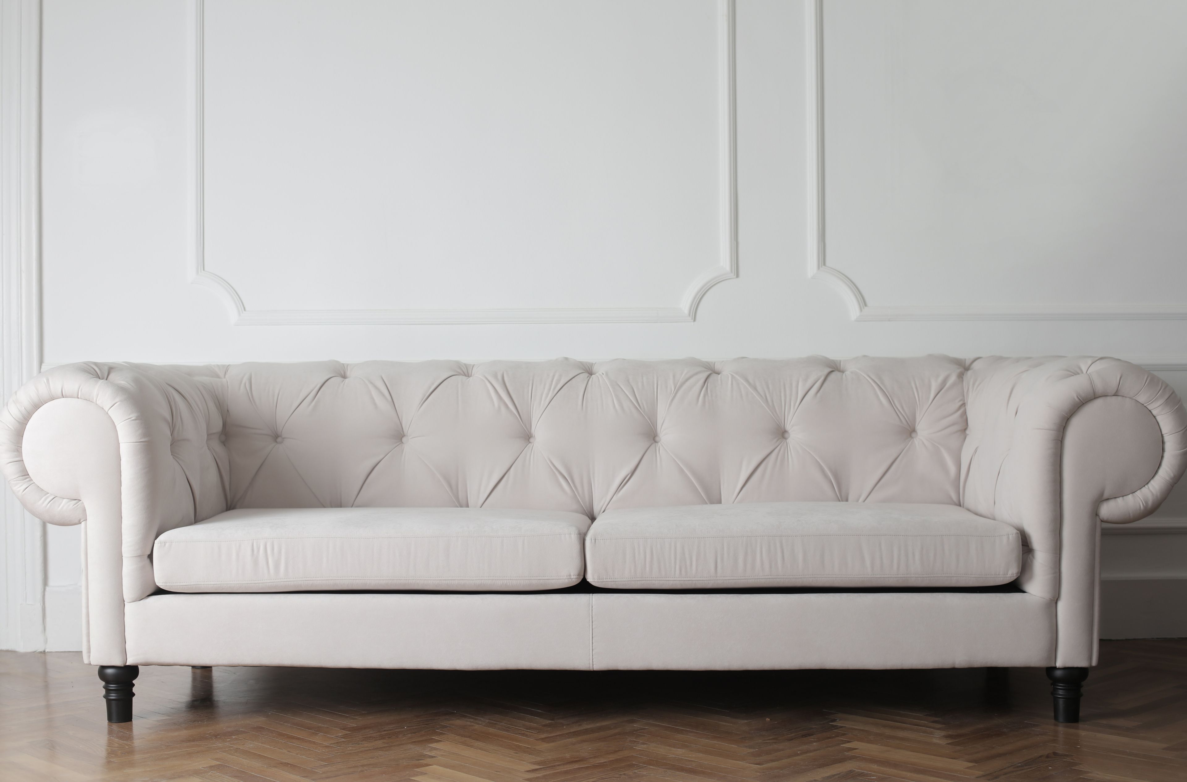 A white chesterfield against panelling