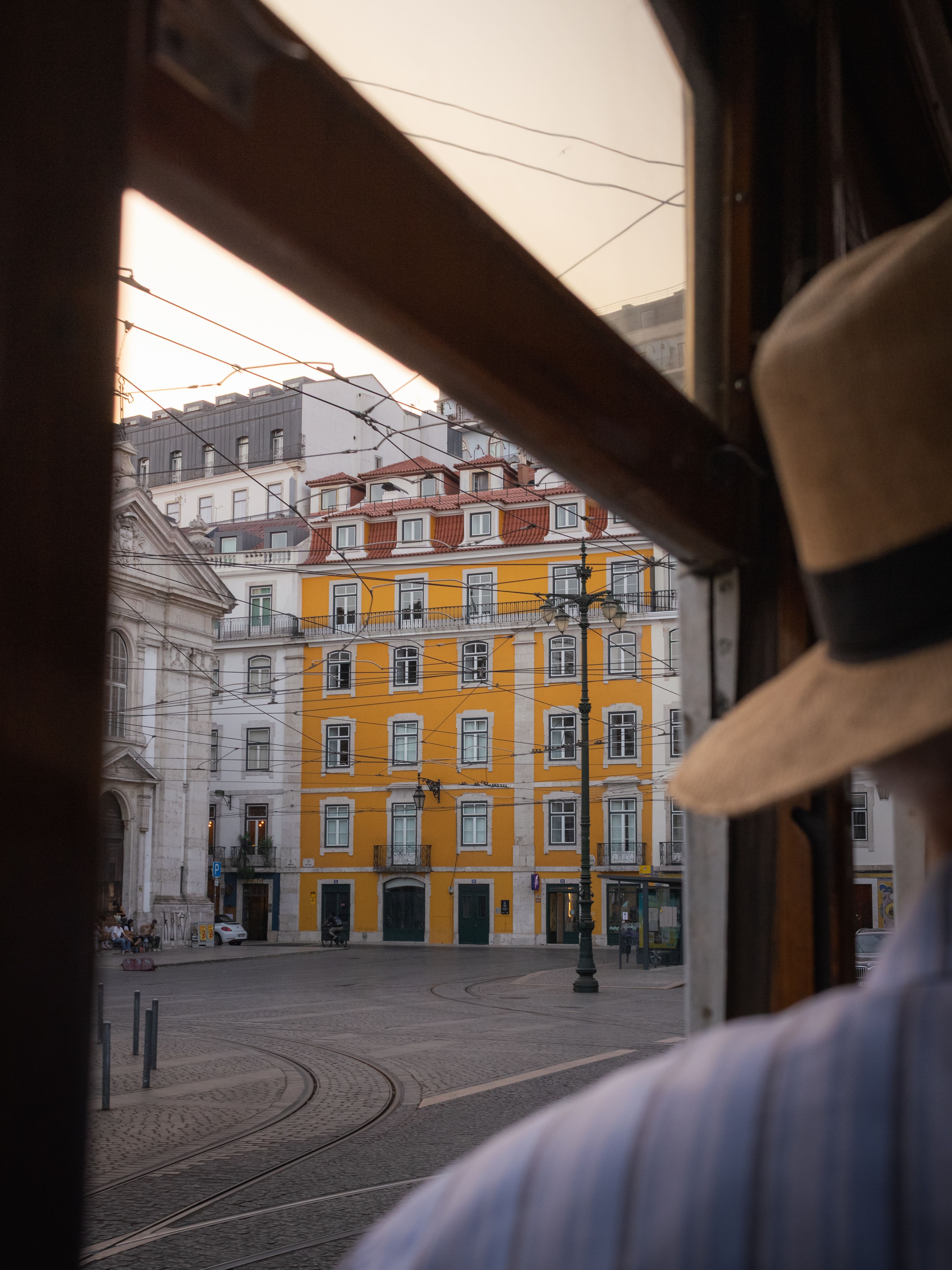 View from a Lisbon tram of a colorful historic building at sunset. Urban exploration in Portugal.