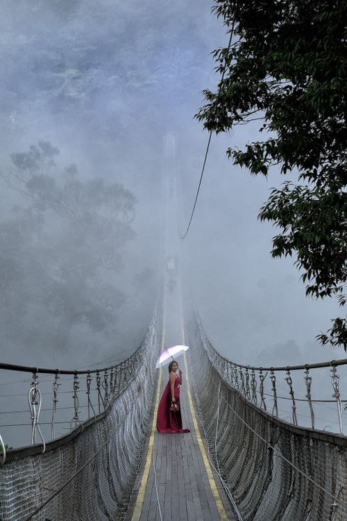Free Woman with umbrella on a foggy bridge in West Java, Indonesia. Stock Photo