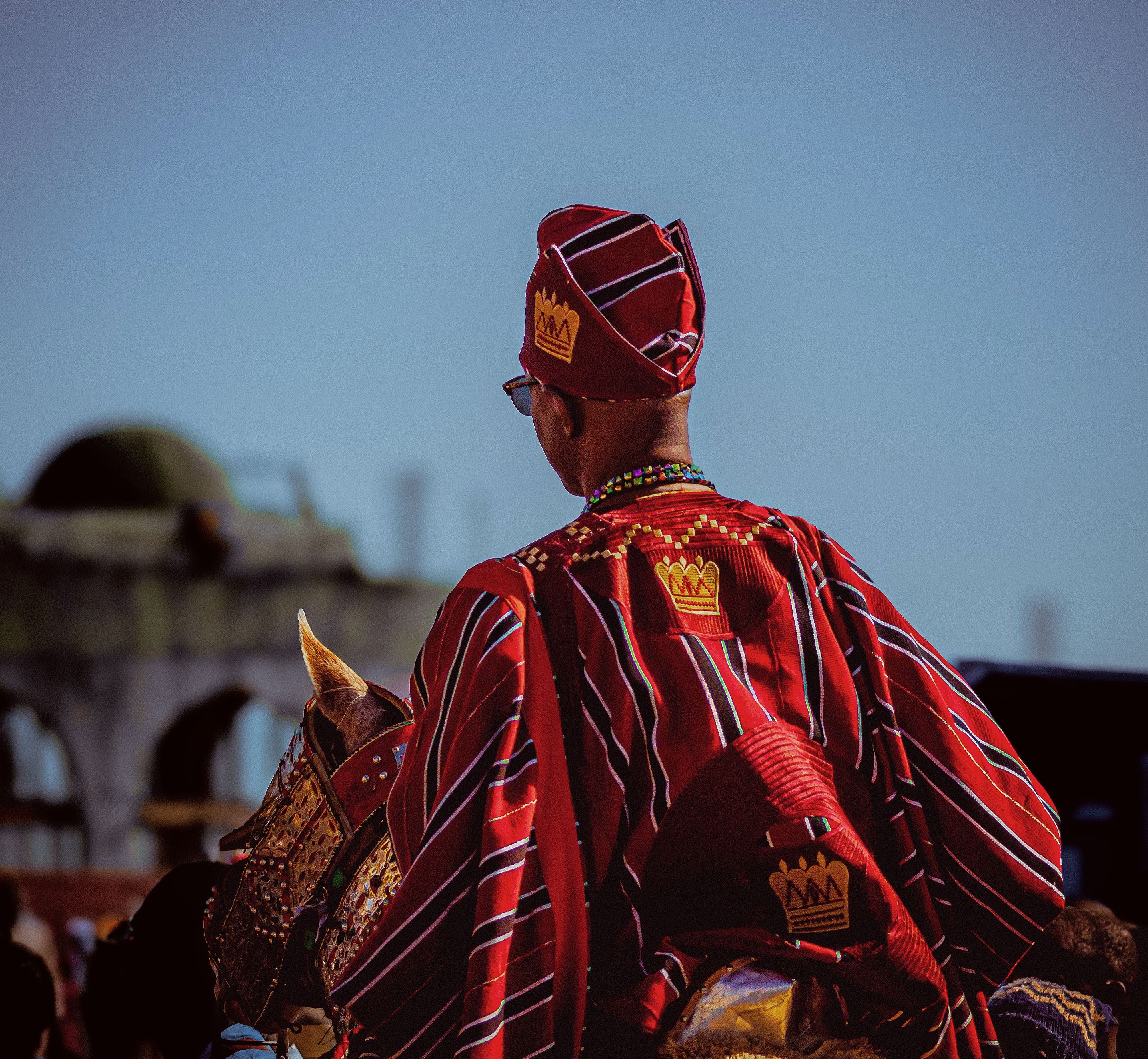 Vibrant traditional attire worn by a man on horseback at a cultural event in Zaria, Nigeria.