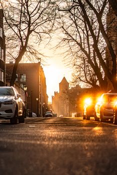 Captivating sunset view of a street in Gdańsk, Poland, with cars and silhouetted trees.