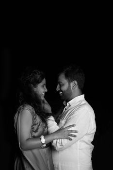 A heartfelt black and white portrait of an Indian couple sharing a joyful moment.