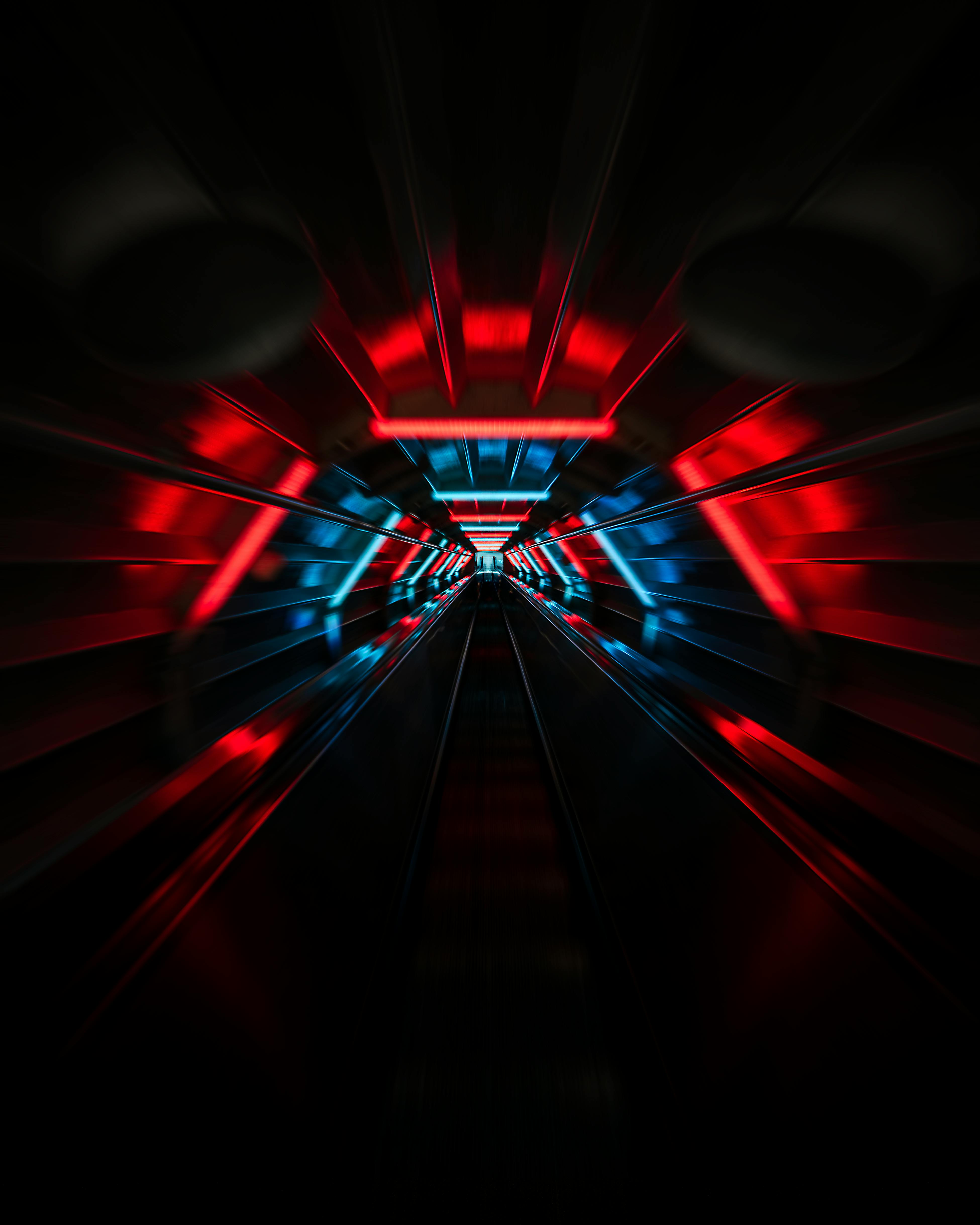 dark urban tunnel with red and blue neon lights