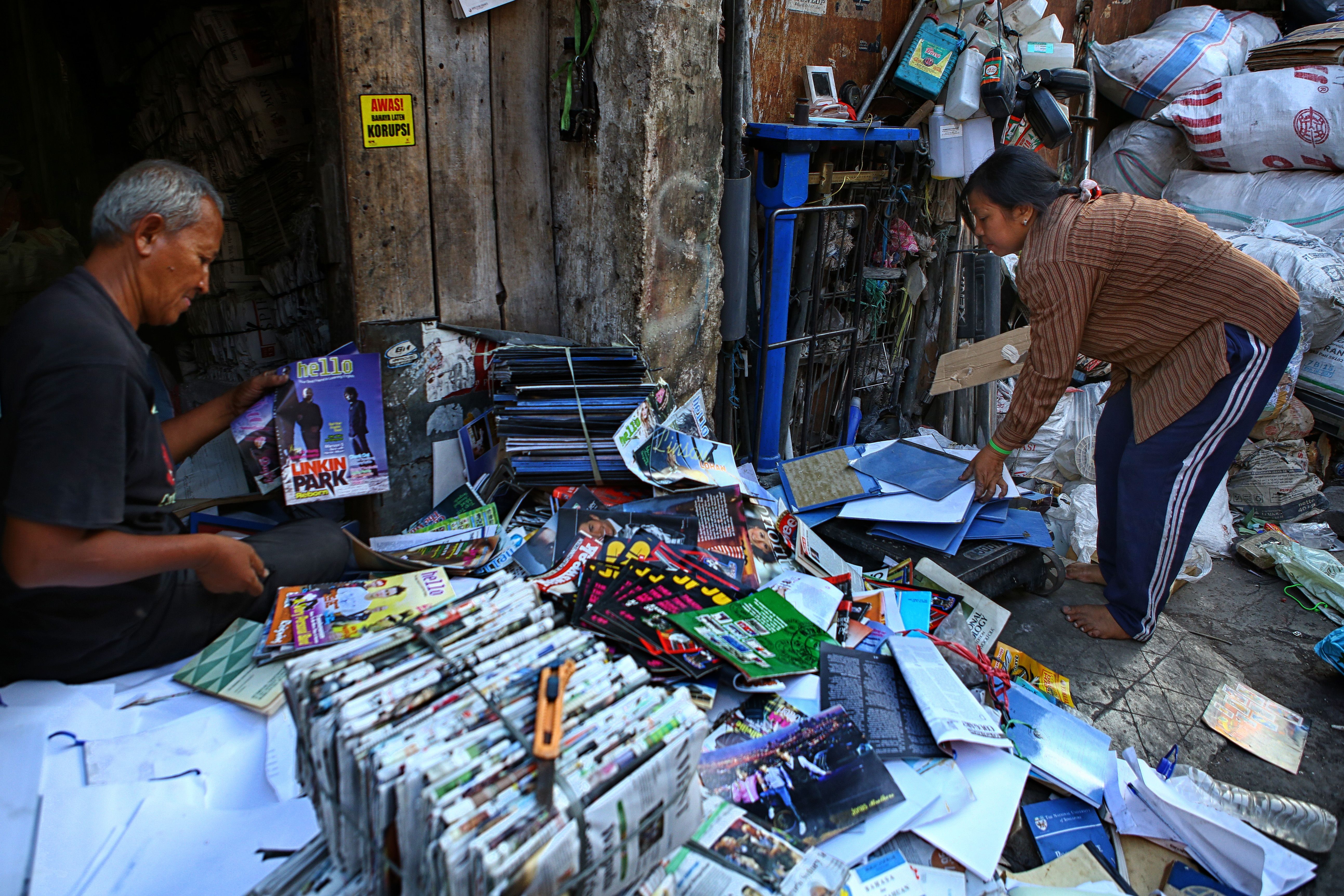 People organizing recyclable paper and magazines in Surakarta, Indonesia.