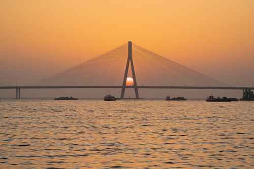 Free Stunning sunset over the Mumbai Sea Link, capturing serene waters and vibrant sky. Stock Photo