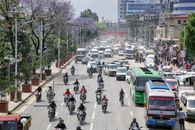 Heavy traffic on a bustling street in Kathmandu, Nepal, featuring buses, cars, and motorcycles.